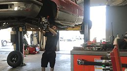 Amherstview Auto mechanic working on vehicle up on hoist